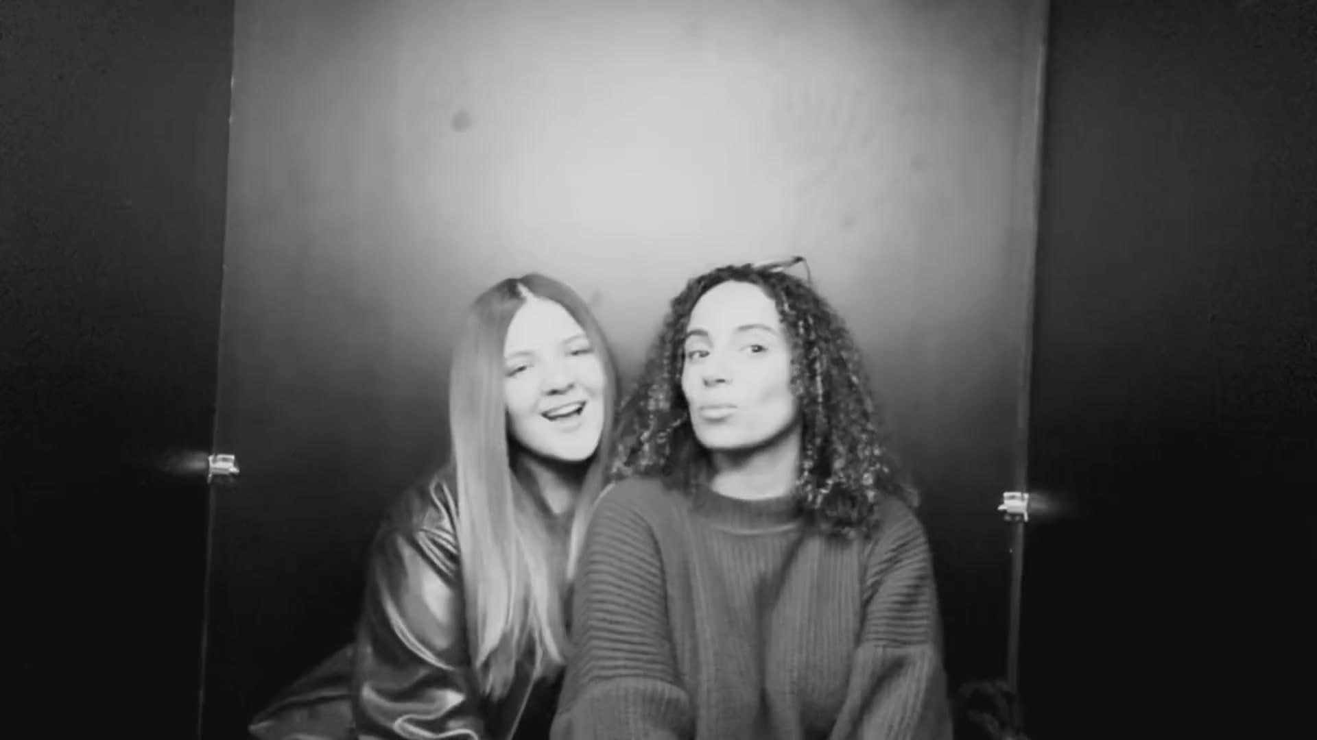 Two friends laughing inside the photo booth